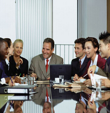multicultural international business meeting with white male at top of table